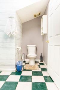 a bathroom with a toilet and a green and white checkered floor at Kamau Farms Cottages in Dawsonville