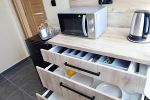 a kitchen with wooden drawers and a microwave at Ubytování U Pupka in Vrbovec