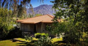 a small house with a mountain in the background at CACHEUTA Casa de Montaña in Ciudad Lujan de Cuyo
