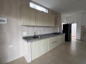 a kitchen with a sink and a black refrigerator at Cabaña Don Jerónimo in Santa Verónica