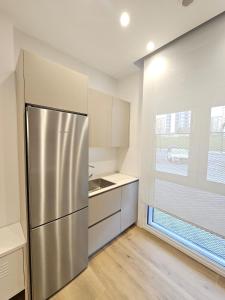 a kitchen with a stainless steel refrigerator and a window at Loft moderno en Lezkairu UAT01756 in Pamplona