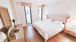 a white bedroom with a large bed and two windows at 2bedroom apartment and condo at Taksim with free parking in Istanbul
