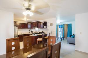 a kitchen and living room with a table and chairs at Cozy, comfortable three-bedroom condo in Santiago,DR in Santiago de los Caballeros