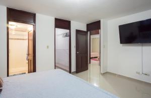 a bedroom with a bed and a flat screen tv at Cozy, comfortable three-bedroom condo in Santiago,DR in Santiago de los Caballeros