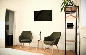 two chairs in a living room with a tv at Lüner Apartment in Lüneburg