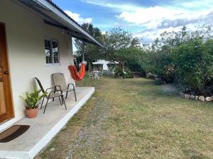 a house with a yard with two chairs on a porch at Venus Lodging House in Alto Boquete