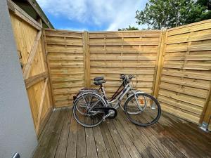 a bike parked on a wooden deck next to a fence at L'Écrin du Neudorf in Strasbourg