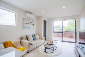 a living room with a couch and a table at 4 bedrooms Retreat with Netflix with Prime Location in Auckland