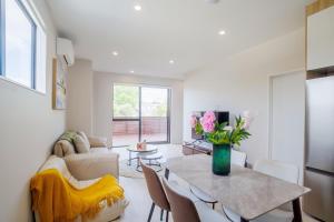 a living room with a table and a couch at 4 bedrooms Retreat with Netflix with Prime Location in Auckland