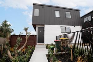 a house with a black and white exterior at 4 bedrooms Retreat with Netflix with Prime Location in Auckland