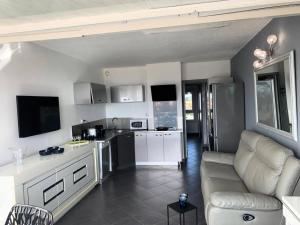 kuchnia i salon z kanapą i stołem w obiekcie Résidence Port Nature Colline 5 - Studio pour 2 personnes numéro 529 - Naturiste w Cap d'Agde