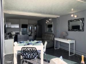 kuchnia i salon z białym stołem i krzesłami w obiekcie Résidence Port Nature Colline 5 - Studio pour 2 personnes numéro 529 - Naturiste w Cap d'Agde