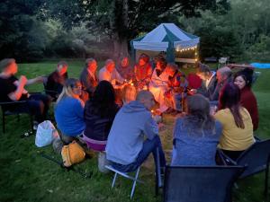 Un groupe de gens assis autour d'un feu dans l'établissement Beautiful Listed Mansion with incredible woodland views, à Huntly