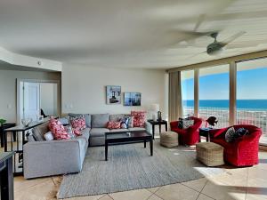 a living room with a couch and chairs and windows at Caribe The Resort #D1114 in Orange Beach