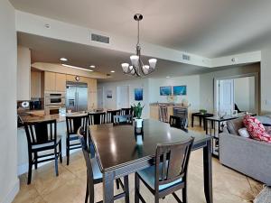 a dining room and living room with a table and chairs at Caribe The Resort #D1114 in Orange Beach