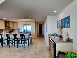 a kitchen with chairs and an island in a room at Caribe The Resort #D1114 in Orange Beach