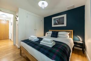 a bedroom with a bed with towels on it at Raven Wing 2 Apartment- Highland Club Scotland in Fort Augustus