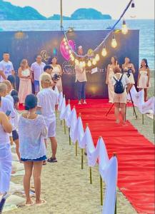 a group of people standing on the beach with a red carpet at Pundaquit Luxury Resort in San Antonio