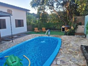 a pool in a yard with a lizard in the water at Chácara com Piscina no Centro da Cidade in Socorro