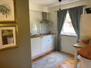 a kitchen with white cabinets and a window at Bärsta Svit BnB in Kolbäck +13 photos