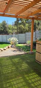 a backyard with a wooden pergola and a yard at Refugio el Amparo de Paine in El Majuelo