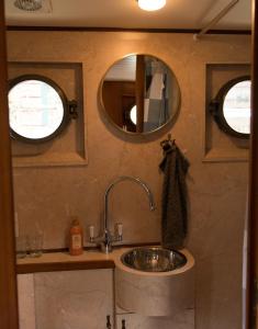 a bathroom with a sink and two mirrors at Salonboot de Wending in Groningen
