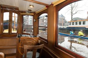 a room with windows and a boat in the water at Salonboot de Wending in Groningen