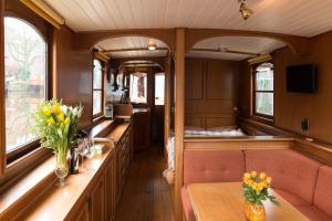 a train car with benches and flowers on it at Salonboot de Wending in Groningen
