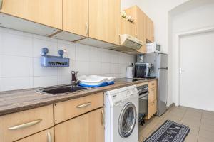 维也纳Superb 2BR Apt Very Spacious At the Millenium Tower的厨房配有水槽和洗衣机