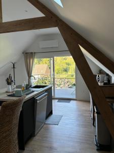 a kitchen with wooden floors and a large window at La Parenthèse in Régnauville