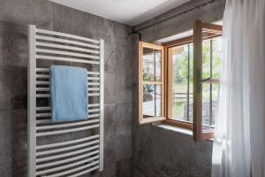 - une salle de bains avec une serviette sur un mur à côté des fenêtres dans l'établissement Das Pumphaus, à Brandenberg