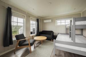 a small bedroom with a bunk bed and a table at Oppmyre Camping in Myre