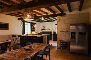 a kitchen with a wooden table and a refrigerator at B&B BienViennue in Marcilly-sur-Vienne