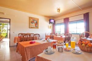 a dining room with two tables and chairs with fruit on them at Ferrinho in Guarda