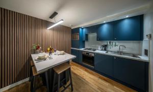 a kitchen with blue cabinets and a counter top at Raven Wing 2 Apartment- Highland Club Scotland in Fort Augustus