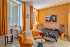 a bedroom with orange walls and a bed and a chair at Vienne in Lyon