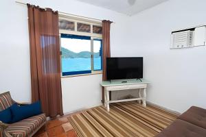 un soggiorno con TV e divano di Casarão dos Pereira - Acesso a Praia da Figueira ad Angra dos Reis
