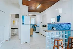 una cucina con mobili bianchi e un frigorifero di Casarão dos Pereira - Acesso a Praia da Figueira ad Angra dos Reis