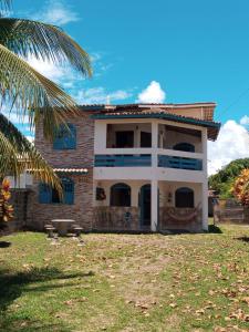a house with a palm tree in front of it at Casa Orí Ayô in Vera Cruz de Itaparica