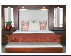 a bedroom with a large bed with orange sheets and pillows at Eden Haven in Edenvale