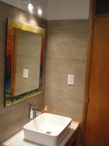 a bathroom with a sink and a mirror at Casa Huarpes MDP en Bosque Peralta Ramos in Mar del Plata