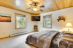 une chambre avec un lit et un ventilateur de plafond dans l'établissement Private Hot Tub and Sauna Bryant Pond Retreat!, à Bryant Pond