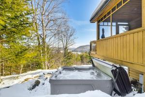 un jacuzzi dans la neige à côté d'une maison dans l'établissement Private Hot Tub and Sauna Bryant Pond Retreat!, à Bryant Pond