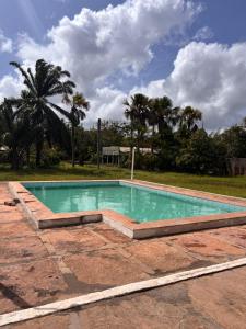 an empty swimming pool in a yard with palm trees at JGM chalés in Barreirinhas