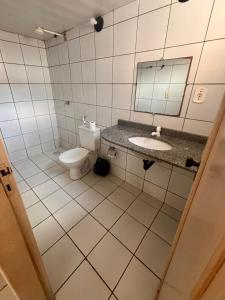 a bathroom with a toilet and a sink and a mirror at JGM chalés in Barreirinhas