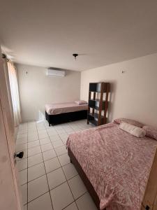 a bedroom with two beds and a tiled floor at JGM chalés in Barreirinhas +1 photo