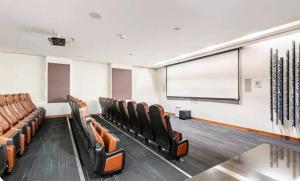 a conference room with leather chairs and a projection screen at Luxury apart with amazing pool, gym, sauna, wifi in Mexico City +102 photos