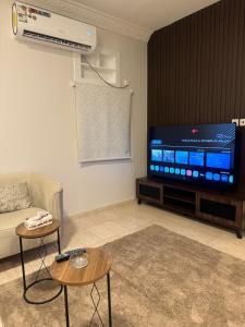 a living room with a couch and a flat screen tv at شقة أنيقة بالزاهر غرفتين وصالة in Makkah
