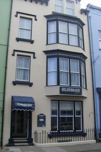 a tall white building with a black and white at Hildebrand Guest House in Tenby