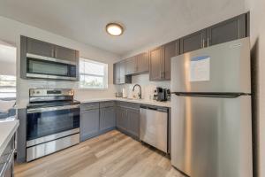 una cucina con elettrodomestici in acciaio inossidabile e armadietti grigi di 1 Mi to Ocean Home with Yard in Boynton Beach! a Boynton Beach Altre 19 foto